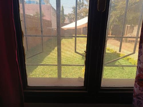 an open window with a view of a yard at AKD Résidence et Automobile in Ouagadougou