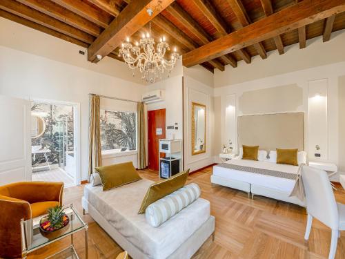 een woonkamer met een bed en een bank bij Hotel Villa Cariola in Caprino Veronese