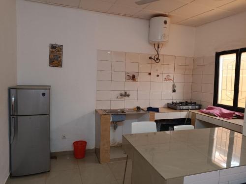 a kitchen with a refrigerator and a counter top at AKD Résidence et Automobile in Ouagadougou