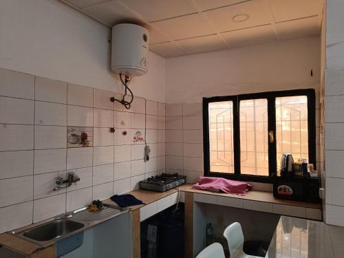 een keuken met een wastafel en een raam bij AKD Résidence et Automobile in Ouagadougou
