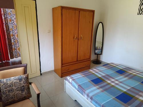 a bedroom with a bed and a cabinet and a chair at AKD Résidence et Automobile in Ouagadougou