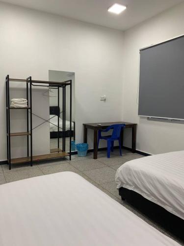 a bedroom with a bed and a desk and a table at 365 Homestay in Kaki Bukit