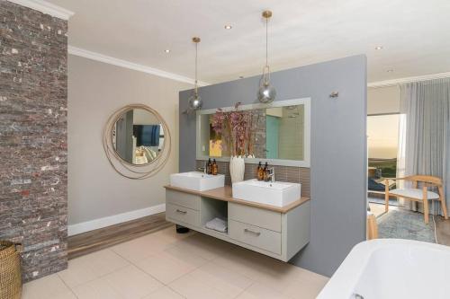 a bathroom with two sinks and a mirror at Luxury Views + Excellence - Pezula no Loadshedding in Knysna