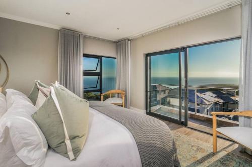 a bedroom with a bed with a view of the ocean at Luxury Views + Excellence - Pezula no Loadshedding in Knysna