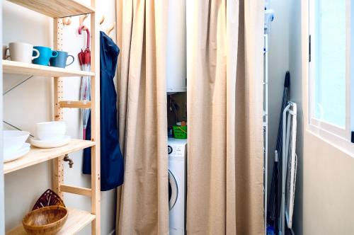 uma cortina de chuveiro numa lavandaria com uma máquina de lavar roupa em Habitación Céntrica en Ferrol em Ferrol