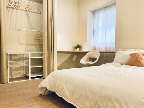 um quarto com uma cama, uma cadeira e uma janela em Habitación Céntrica en Ferrol em Ferrol