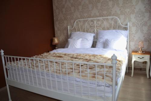 - une chambre avec un lit blanc et des oreillers blancs dans l'établissement Apartament Premium Retro, à Połczyn-Zdrój