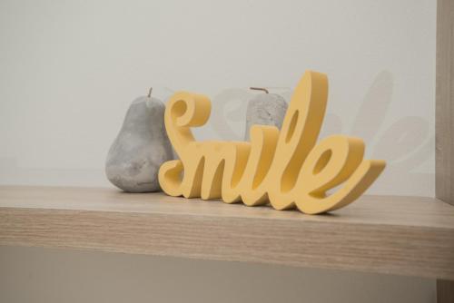 a wooden sign that says smile sitting on a shelf at Athina Residence in Léntas
