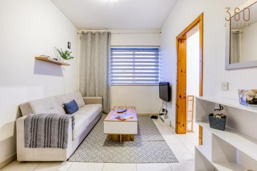 ein Wohnzimmer mit einem Sofa und einem Tisch in der Unterkunft Cosy & Stylish 1BR home in The Heart of Gzira by 360 Estates in Gżira