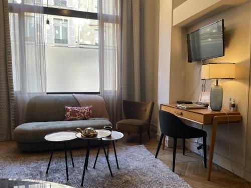 a living room with a couch and a table and a desk at Loft Royal des Promenades in Reims