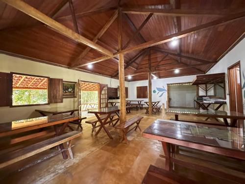 a large room with wooden tables and benches at Pousada J Country in Sana