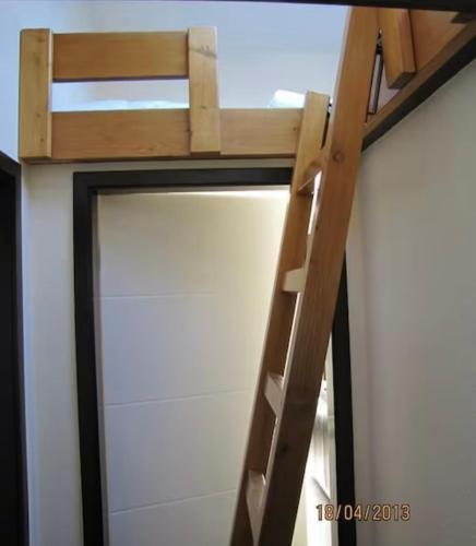 a loft bed with a ladder in a room at Henneliebe am Hennesee in Meschede
