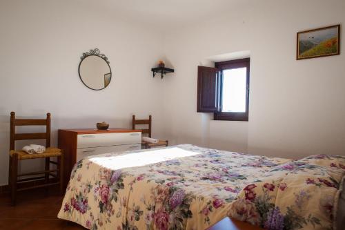 een slaapkamer met een bed, een dressoir en een spiegel bij Casa Ladyhawke in Santo Stefano di Sessanio
