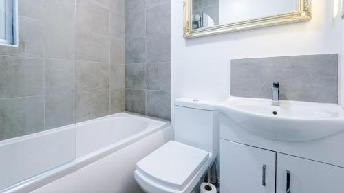 een witte badkamer met een wastafel en een toilet bij Perfect for Business Guests or Leisure in Hough Green
