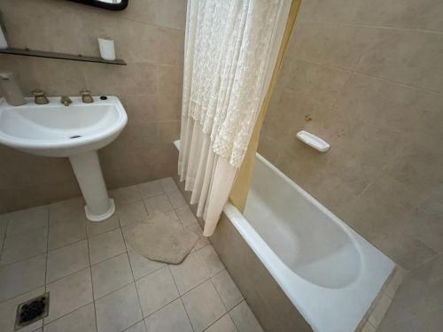 een badkamer met een wastafel, een bad en een toilet bij Casa Muy Céntrica in Gualeguaychú