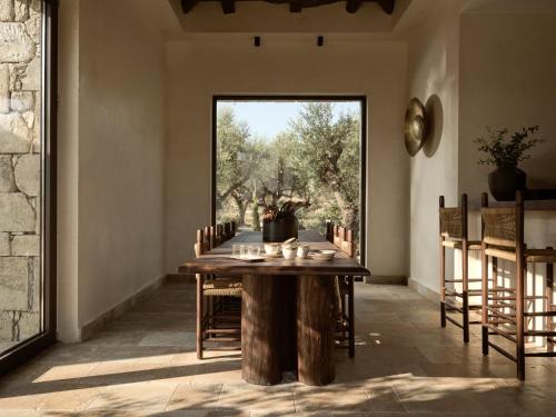 a dining room with a table and a large window at Pierros Verde in Lithakia