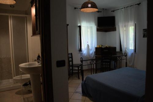 a bedroom with a bed and a sink and a bathroom at Casale del Gufo in Chiaravalle