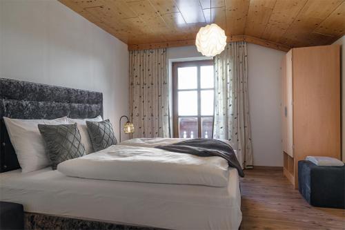 - une chambre avec un grand lit et une fenêtre dans l'établissement Alpen-Nest Großarl, à Grossarl