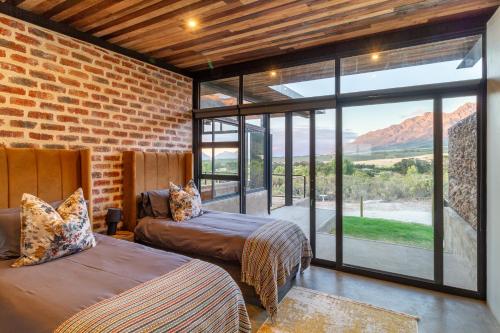 Zimmer mit 2 Betten und einem großen Fenster in der Unterkunft Steenbok farm cottages Kingfisher Cottage in Wolseley