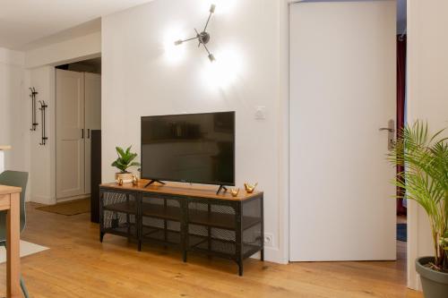 a living room with a flat screen tv on a table at Delalauret Apartment - Vannes Centre in Vannes