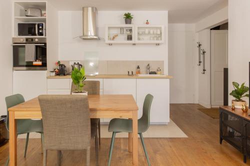 a kitchen and dining room with a wooden table and chairs at Delalauret Apartment - Vannes Centre in Vannes