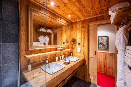 a bathroom with two sinks in a wooden cabin at Hôtel Au Chamois d'Or by Les Etincelles in L'Alpe-d'Huez