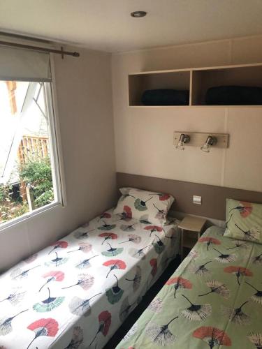 une chambre avec un lit et une fenêtre dans l'établissement Mobil home Camping les dunes - les Conches, à Longeville-sur-Mer