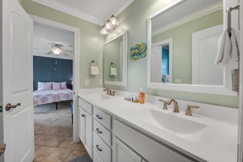 a bathroom with two sinks and a large mirror at Bird's Nest in Holden Beach