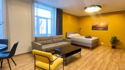 a living room with a couch and a bed at Kastani Factory Apartments in Tartu