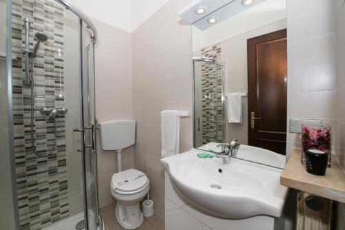 y baño con lavabo, aseo y ducha. en Appartamenti Gianni, en Torri del Benaco