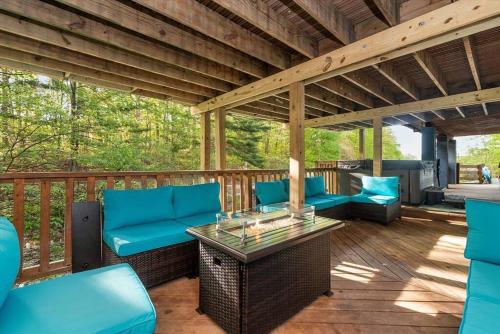 a patio with blue chairs and a table on a deck at King Suites, Lakefront, Hot Tub, Watercraft in Harpers Ferry