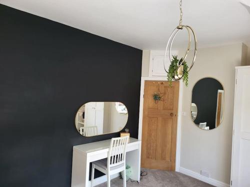 a room with a desk and two mirrors on a wall at Sunbeams and ice creams in Scarborough