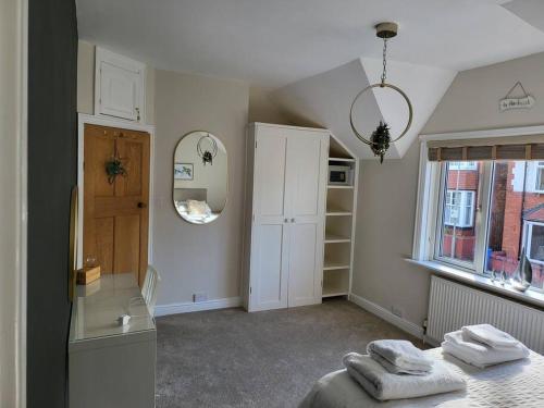 a bedroom with a bed and a mirror and a window at Sunbeams and ice creams in Scarborough