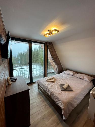 a bedroom with a bed and a large window at Cabana Cerbului in Cluj-Napoca