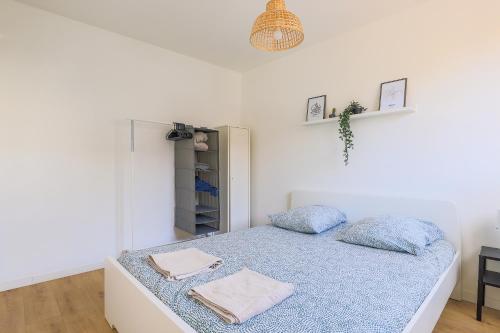 um quarto com uma cama com duas almofadas em Appartement Familial - Avec Parking Privé Gratuit em Arras