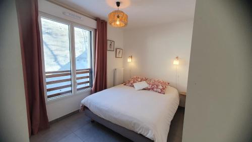 a small bedroom with a bed and a window at T3 STANDING CENTRE STATION VALBERG in Valberg