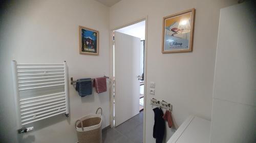 a white bathroom with a mirror and a hallway at T3 STANDING CENTRE STATION VALBERG in Valberg