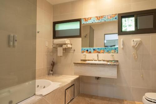 uma casa de banho com um lavatório e um espelho. em Village Cataratas em Porto Iguaçu