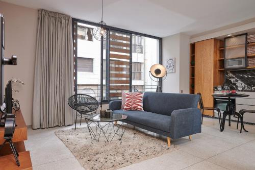 un soggiorno con divano blu e tavolo di Stayhere Casablanca - Gauthier 3 - Urban Residence a Casablanca