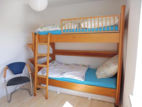 2 Etagenbetten in einem Zimmer mit einem Stuhl in der Unterkunft Bobis Ferienwohnung in Wildpoldsried