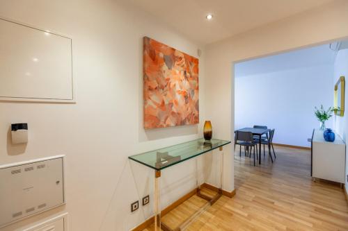 a room with a glass table and a painting on the wall at Apartamento Lisboa Sete Rios in Lisbon