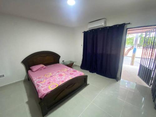 a bedroom with a pink bed in a room at Comfortable apartment very close to the airport in Cúcuta