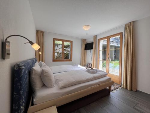 ein Schlafzimmer mit einem großen Bett und einem Fenster in der Unterkunft Chalet Bergrose 3 in Wengen