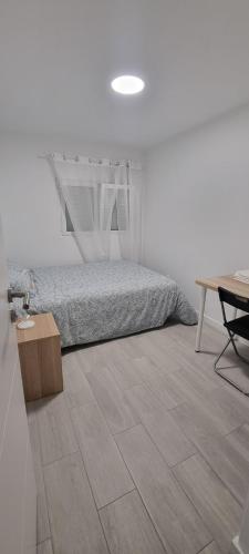 sypialnia z łóżkiem, stołem i biurkiem w obiekcie Chinde Guesthouse w Lizbonie