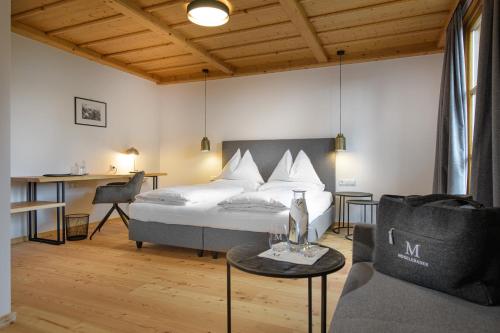 バート・ザンクト・レオンハルト・イム・ラヴァントタールにあるHotel Moselebauerのベッドルーム1室(ベッド1台、ソファ、テーブル付)