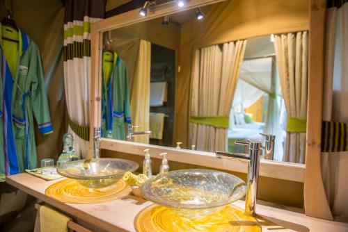 ein Badezimmer mit zwei Waschbecken und einem großen Spiegel in der Unterkunft Soroi Private Wing in Masai Mara