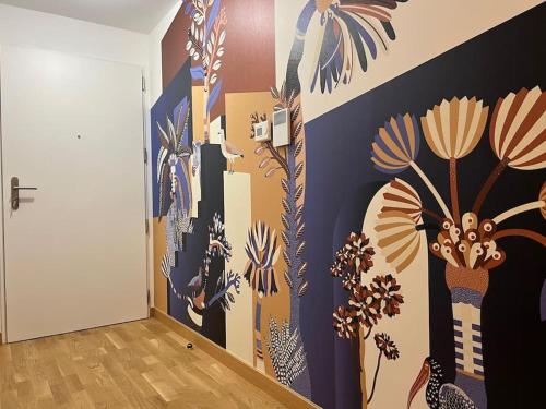 a hallway with a mural of flowers on the wall at Secret garden Calme et terrasse en hyper-centre in Grenoble
