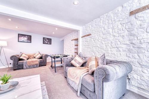 a living room with two couches and a stone wall at Deluxe Gem of Bath - Football Table - Sleeps 10 in Bath