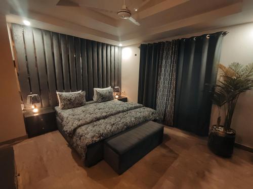 a bedroom with a bed and a couch and curtains at Stay in Comforts in Islamabad