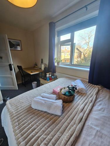 a bedroom with a bed with towels and a window at Double bedroom located close to Manchester Airport in Wythenshawe